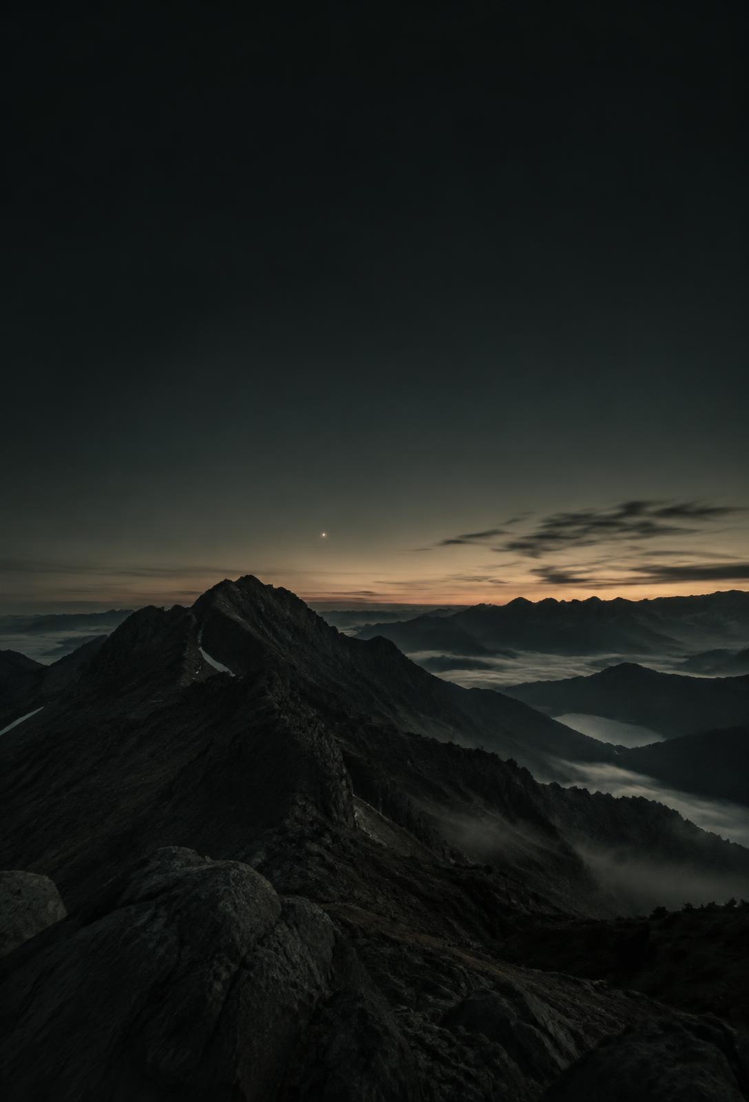 Mountain ridge under a single bright star at dawn